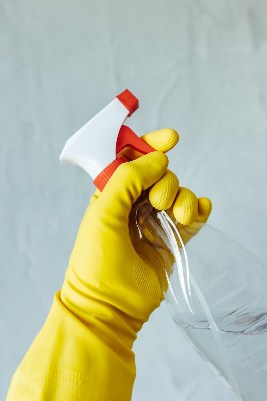 cleaning with yellow rubber gloves and spray bottle